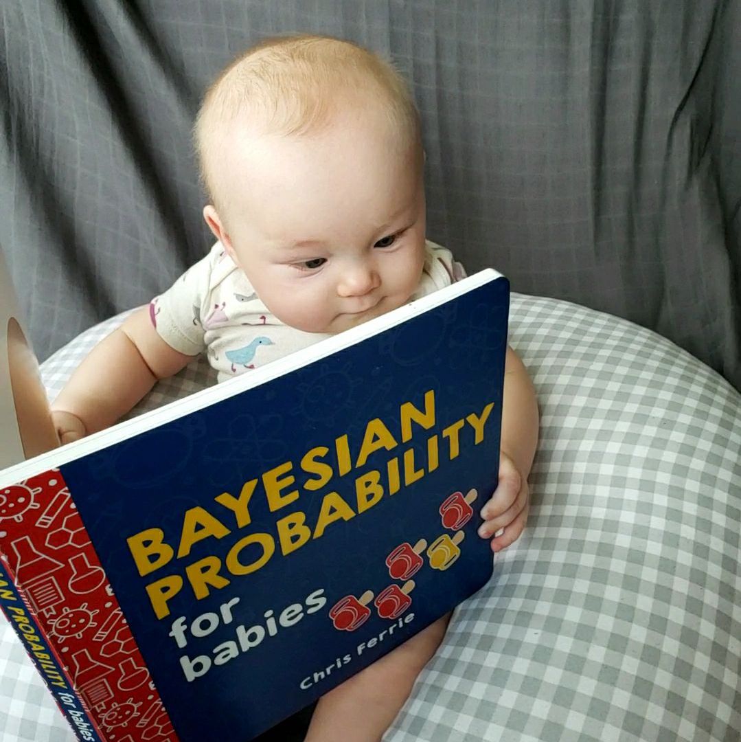 Baby holding a book about bayesian probability