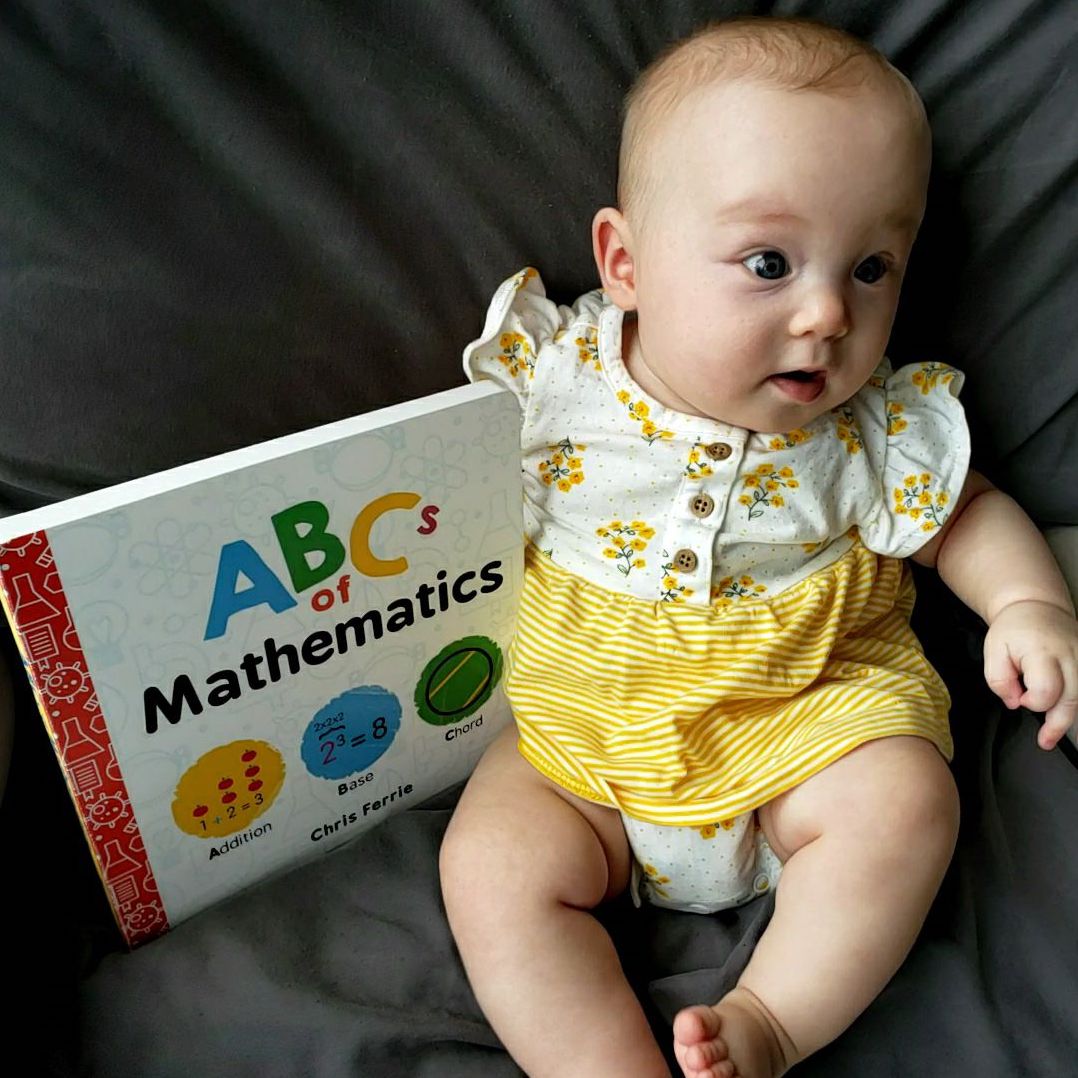 Baby holding a book about ABCs of math